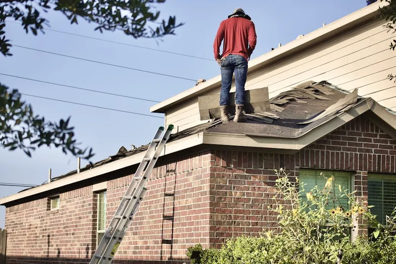Professional roofer working on a residential roof in Pulliam
